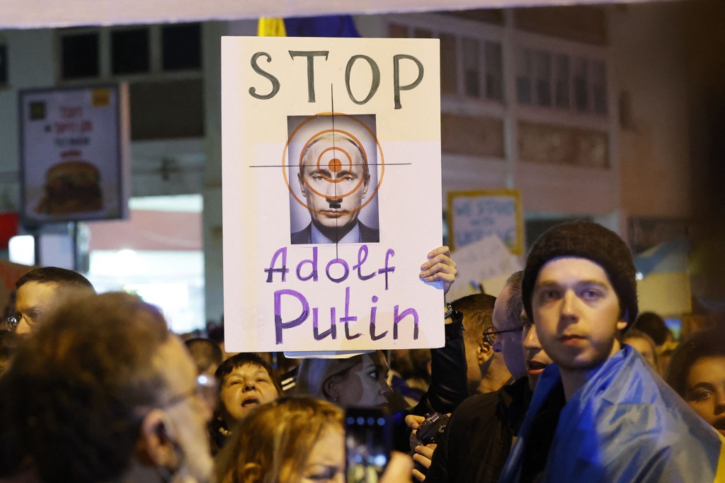 Demonstrators hold placards in front of the Russian Embassy in Tel Aviv protesting the invasion. 