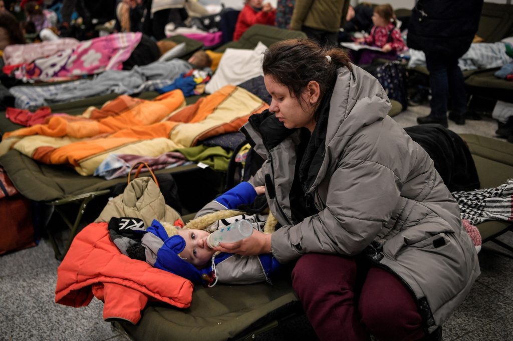 A woman feeds a child as they and other refugees from Ukraine rest at a temporary shelter in the main train station of Krakow, Poland on March 6.