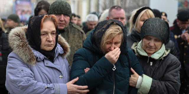 Relatives of Colonel Vladimir Chuga, commander of a reconnaissance battalion of the self-proclaimed Donetsk People's Republic during a farewell ceremony in Donetsk, eastern Ukraine, Monday, March 7, 2022. Chuga was posthumously awarded the title Hero of the Russian Federation.  . 