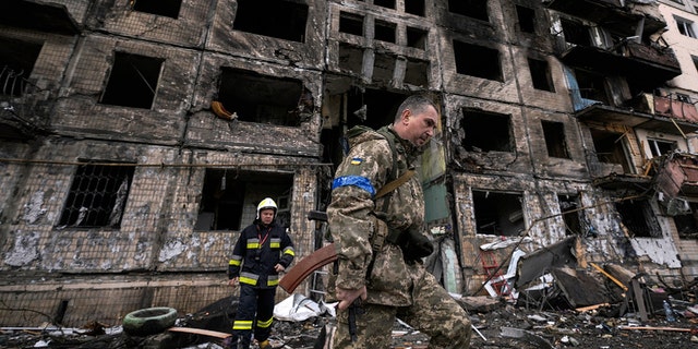 Ukrainian soldiers and firefighters search a destroyed building after a bomb attack in Kyiv, Ukraine, Monday, March 14, 2022 (AP Photo/Vadim Ghirda)