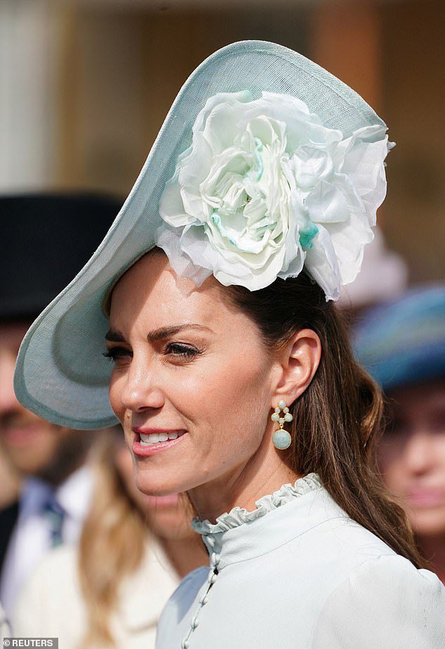 Kate Middleton was snapped wearing a £140 pair of aquamarine dangler earrings at a garden party at Buckingham Palace yesterday (pictured)