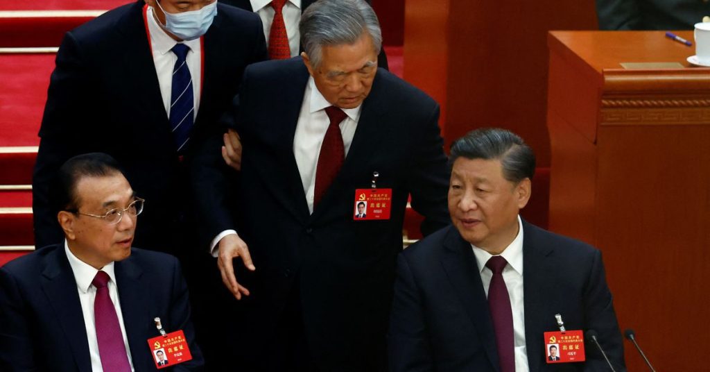 Former Chinese President Hu Jintao is escorted out of the Party Conference